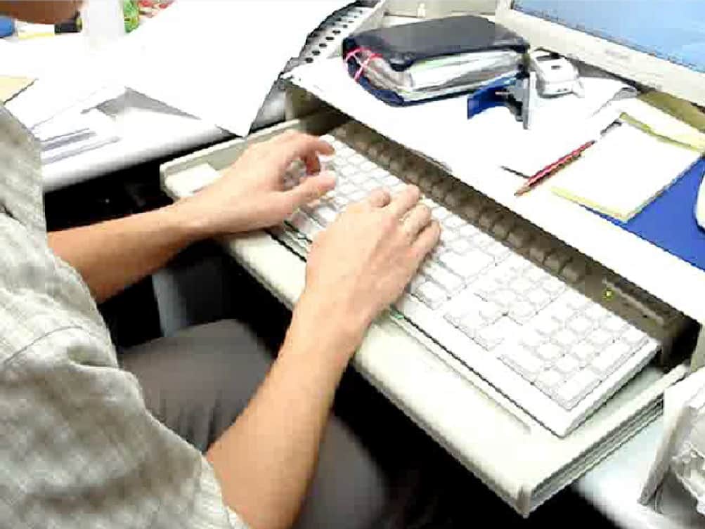 A man typing on a computer keyboard